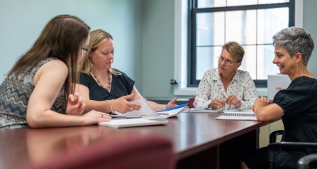 Samantha Koury and Susan Green discuss ITTIC's Trauma-Informed Organizational Change Manual with social workers from the Ken-Ton School District. 